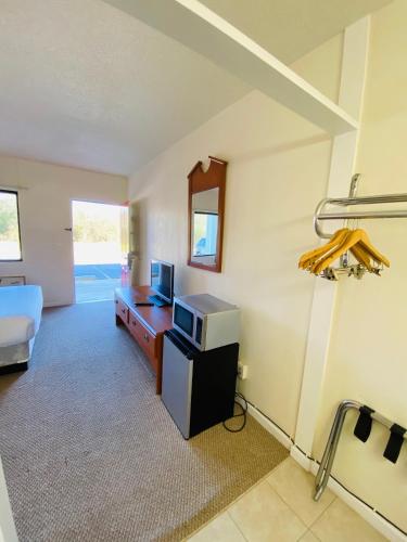 a living room with a tv and a bed in a room at Traveler's Place Inn & Suites in Scottsboro