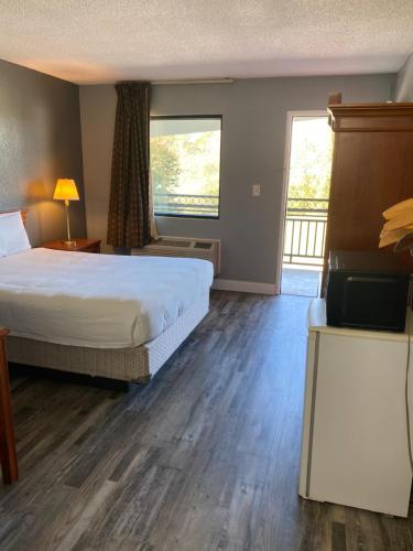 a hotel room with a bed and a television at Traveler's Place Inn & Suites in Scottsboro