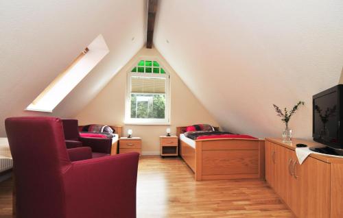 a attic room with two chairs and a tv at Schloms Hof in Waffensen