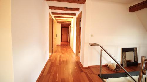 a hallway with white walls and wooden floors and a fireplace at Ferienwohnung am Wasserschloss 1-3 in Ochsenfurt
