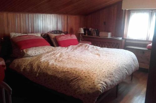 una camera da letto con un letto con cuscini rossi e una finestra di Joie de Vivre Gressoney St Jean a Gressoney-Saint-Jean