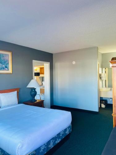 a bedroom with a large bed and a blue wall at Traveler's Place Inn & Suites in Scottsboro
