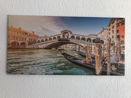 a painting of a bridge and a boat on a river at Venice Apartment in Interlaken