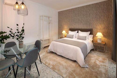 1 dormitorio con 1 cama grande y mesa de cristal en Wanderlust Malaga Apartamentos 2, en Málaga