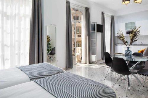 sypialnia z łóżkiem i stołem z krzesłami w obiekcie Wanderlust Malaga Apartamentos 3 w Maladze