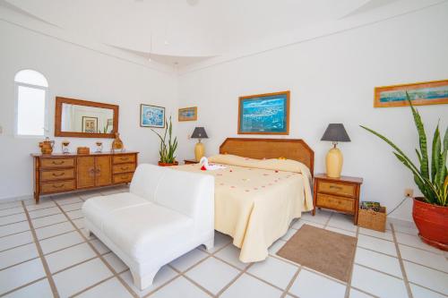 a bedroom with a bed and a white chair at Villas Fasol Huatulco in Santa Cruz Huatulco