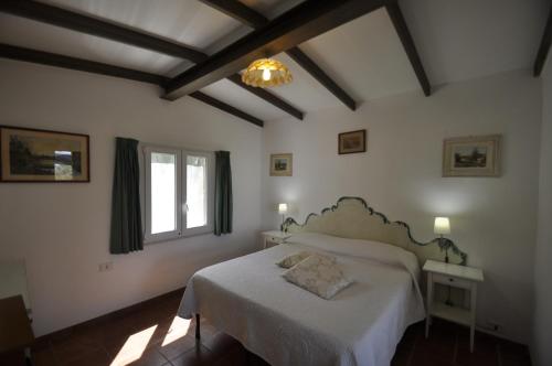 a bedroom with a white bed and a window at Villa Eva in Anacapri