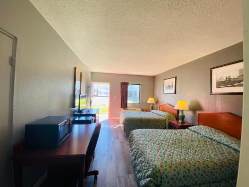 a hotel room with two beds and a table at Traveler's Place Inn & Suites in Scottsboro