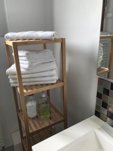 - une pile de serviettes sur un porte-serviettes dans la salle de bains dans l'établissement LE CATALPA - centre ville, jardin & parking!, à Annecy