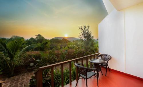 a balcony with a view of a sunset at Exotica By The Sea in Diveagar