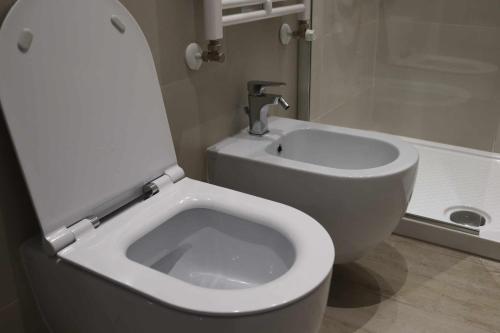 a bathroom with a white toilet and a sink at Sun Bologna in Bologna