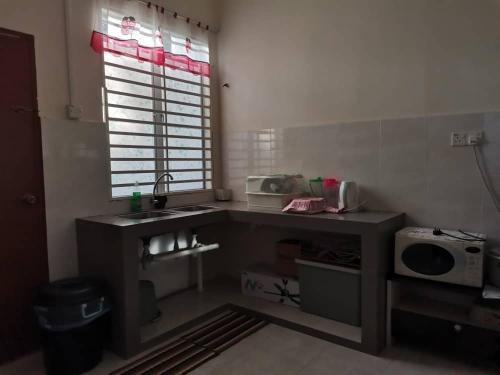 a small kitchen with a sink and a microwave at Villa Pulai Indah Temerloh in Temerloh