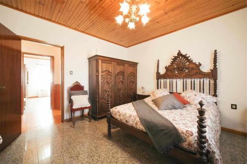 a bedroom with a large bed and a chandelier at Casa Rural do Salgueirinho in Santo Tirso
