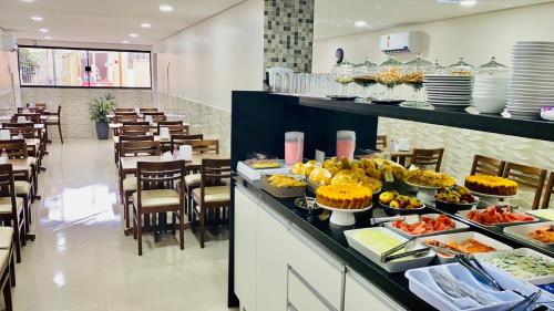 una línea de buffet con comida expuesta en un restaurante en Hotel Praça da Árvore, en São Paulo