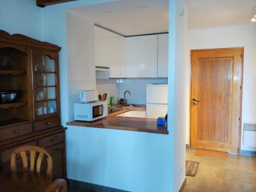 une cuisine avec des armoires blanches et un comptoir dans l'établissement Apartamento dúplex en Bourg Madame, à Bourg-Madame