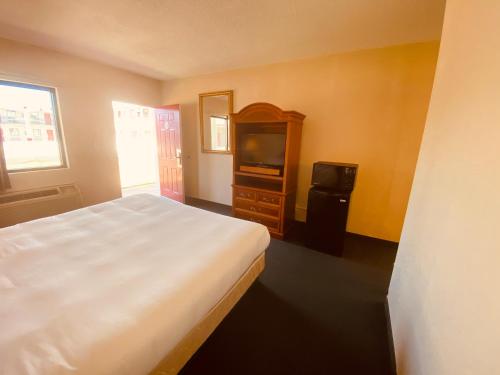 a bedroom with a bed and a tv in it at Traveler's Place Inn & Suites in Scottsboro