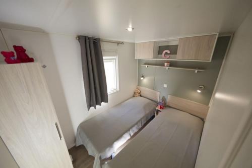 a small room with two beds and a window at Maïana Resort in La Grande-Motte