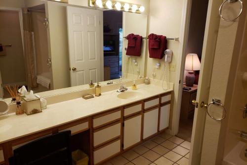 Un baño con lavabo y un espejo grande. en Foothill's Luxury 2BDR Ground Floor Condo in 1000 Hill's, en Branson