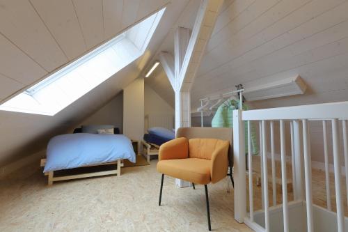 Schlafzimmer im Dachgeschoss mit einem Bett und einem Stuhl in der Unterkunft Ferienwohnung goldener Mond in Mastershausen
