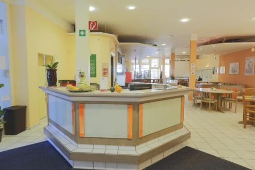 a large kitchen with a counter in a room at Sportpark Hotel Isernhagen in Isernhagen