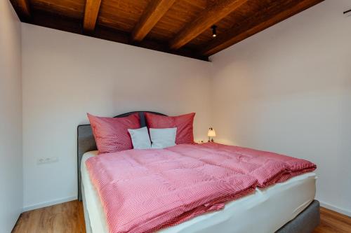 een slaapkamer met een bed met roze dekens en kussens bij Apartment Bergblick in Reith bei Seefeld