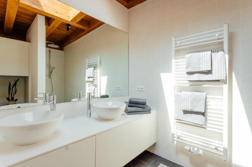 a white bathroom with two sinks and a mirror at Apartment Bergblick in Reith bei Seefeld