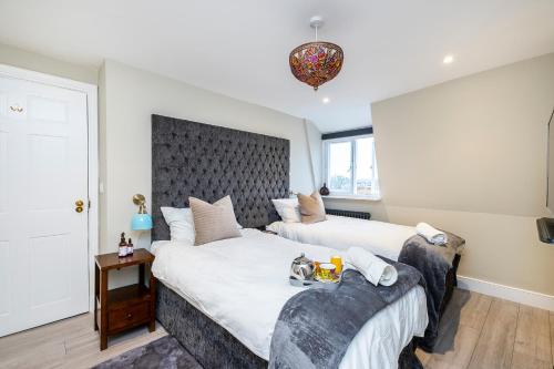 a bedroom with two beds and a table at King Square Serviced Apartments in Bridgwater