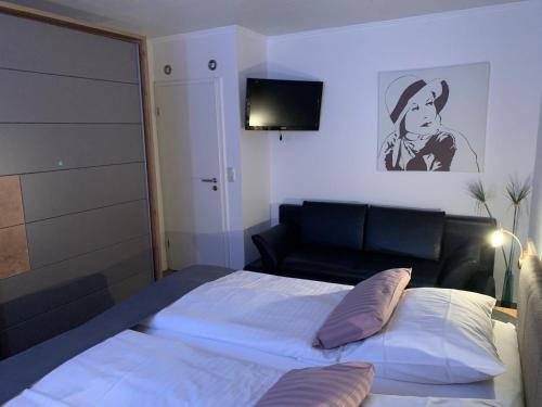 a bedroom with a bed and a couch and a television at Haus-Encore-Wohnung-3 in Büsum