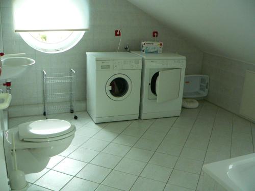 a bathroom with a toilet and a washing machine at WBHS53001-Die-Ostsee-so-nah in Westerbergen