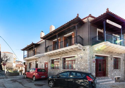 a building with two cars parked in front of it at Luxury Studios & Cozy Apartments by White Hills in Arachova