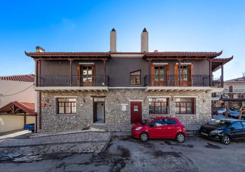 a house with a red car parked in front of it at Luxury Studios & Cozy Apartments by White Hills in Arachova