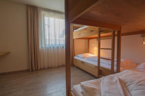 sypialnia z dwoma łóżkami piętrowymi i oknem w obiekcie Max Residence Zell am See - Steinbock Lodges w mieście Zell am See