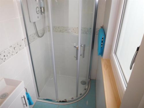 a shower with a glass door in a bathroom at Surfside Chalet in Dunbar