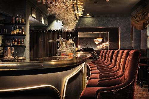 a bar with a row of leather bar chairs at Stora Hotellet; BW Premier Collection in Umeå