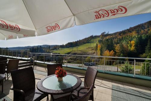 a patio with a table and chairs on a balcony at Hotel Pegaz in Krynica Zdrój