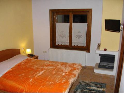 マクリニツァにあるKirmilis Mansionのベッドルーム(ベッド1台、窓、テレビ付)