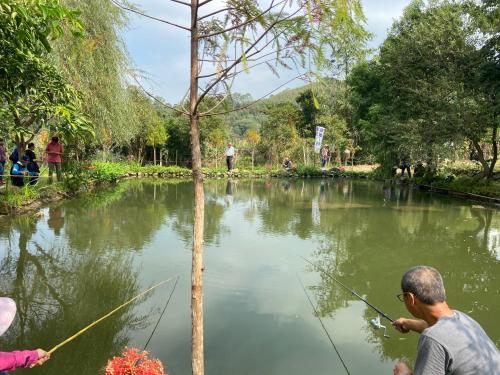 a man fishing in a river with a rod at 進泉莊民宿 有卡拉ok可以烤肉可以帶寵物 in Miaoli
