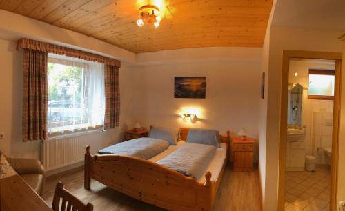 1 Schlafzimmer mit einem großen Bett und einem Badezimmer in der Unterkunft Gasthof PANORAMA in Ehrwald