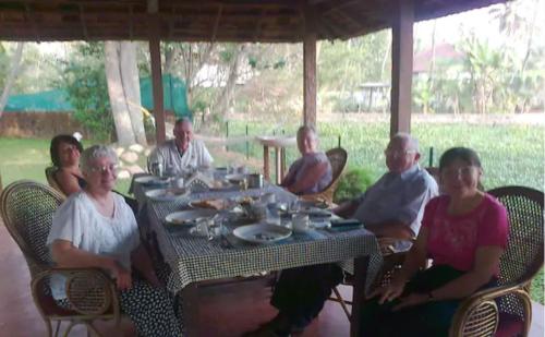 a group of people sitting around a table at Lovedale Lakeside Homestay in Alleppey