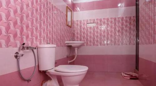 a pink bathroom with a toilet and a sink at Lovedale Lakeside Homestay in Alleppey