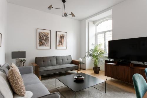 un soggiorno con divano e TV a schermo piatto di Prata Street-Your Home in Lisbon a Lisbona