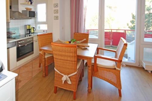 キュールングスボルンにあるDuenengarten-Schwalbennest-am-Meer-9662のキッチン(木製のテーブル、椅子、テーブル、椅子付)