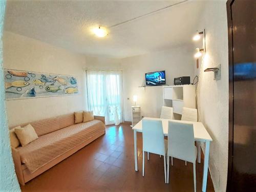 a living room with a couch and a table and chairs at Terza Spiaggia & La Filasca - Apartments in Golfo Aranci