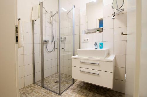 ein Bad mit einem Waschbecken und einer Dusche in der Unterkunft Frau Clara Haus - Ecke 1 in Eckernförde