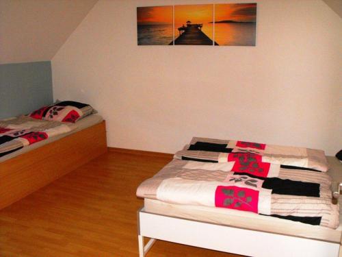 a bedroom with two beds and a picture on the wall at Ferienwohnung-Thielen-Waldrach-Ruwertal in Waldrach
