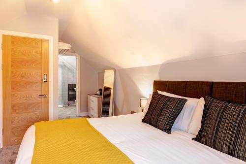 ein Schlafzimmer mit einem großen Bett und einer gelben Decke in der Unterkunft Bondgate Hotel East Midlands Airport in Castle Donington