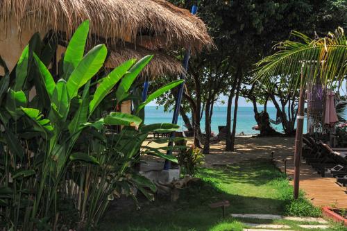 a resort with a grass hut and the ocean at LaLaanta Hideaway Resort in Ko Lanta