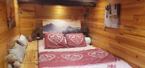 1 dormitorio con 1 cama con almohadas rojas y blancas en Le Havre de paix en Saint-Dalmas-le-Selvage