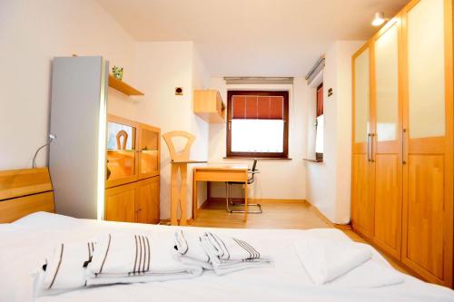 1 dormitorio con cama blanca y escritorio en App-Kuestenperle, en Westerland