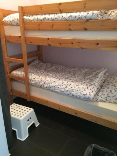 a bunk bed with a wooden bunk bed frame and a stool at Ferienwohnung-Koehler-2 in Altreichenau